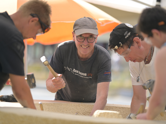 Bildhauer Lothar Nickel und andere Personen arbeiten am Brunnenstein.