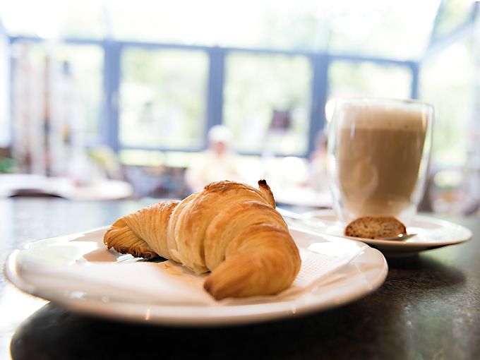 Croissant und Latte Macchiato auf der Theke stehend