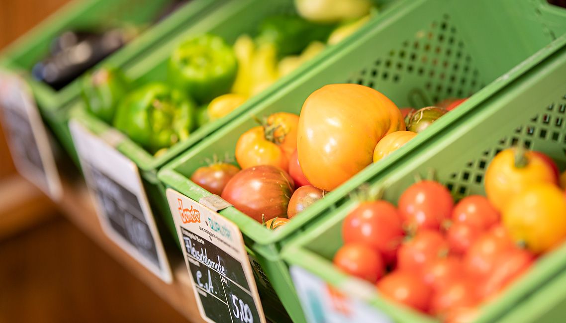 Gemüsekisten mit Tomaten im Hofladen